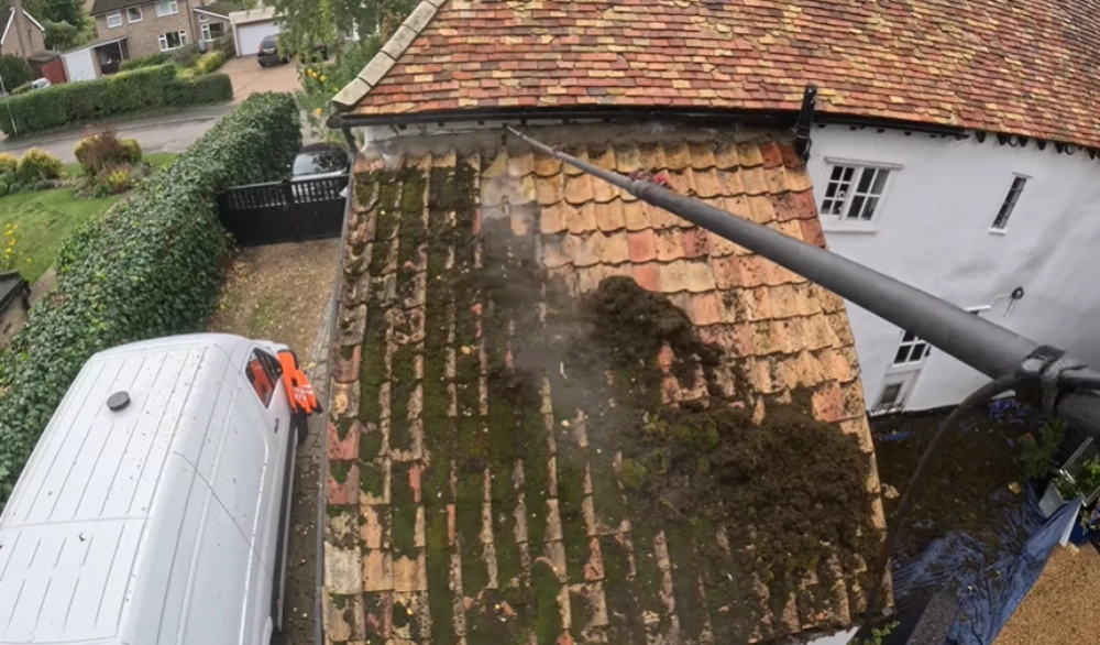 Cleaning moss off a lower roof section