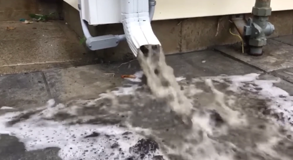 Flushing downspout debris with water