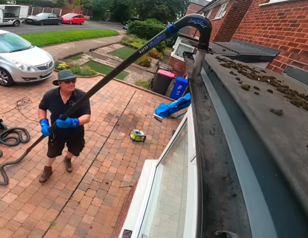 Cleaning gutters from the ground with a gutter vacuum pole