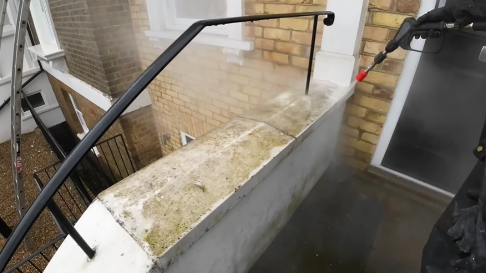 Hot water pressure washing concrete wall