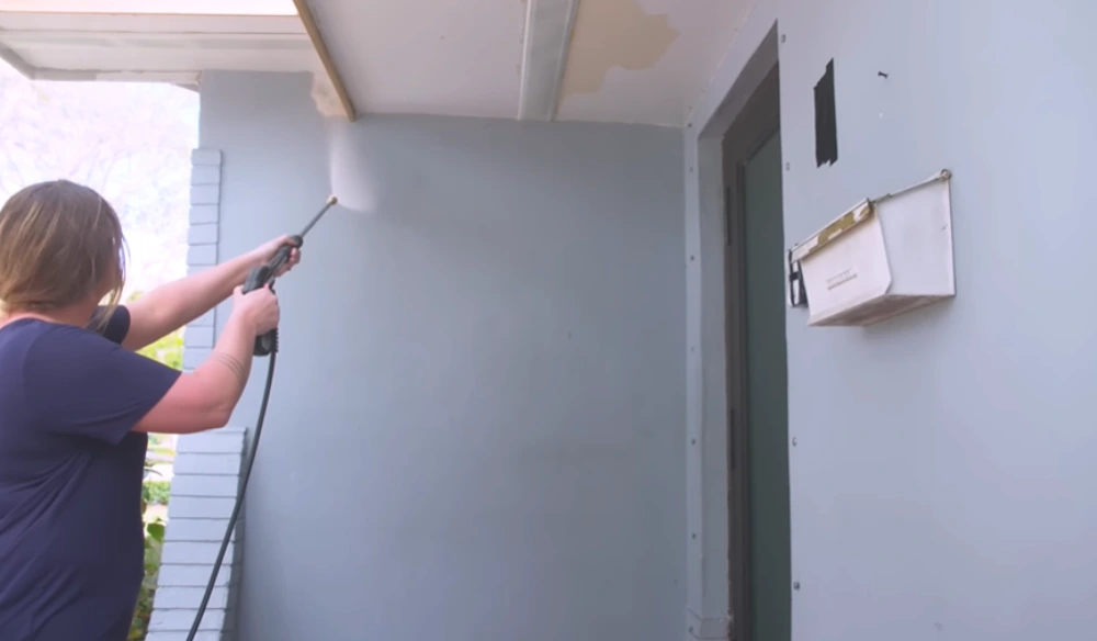 Pressure washing entryway wall