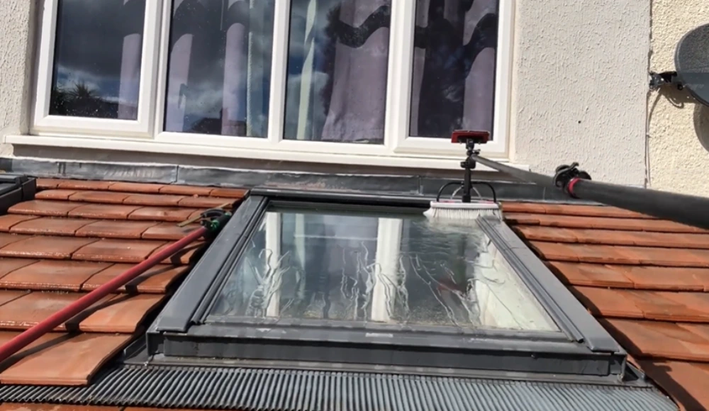 Scrubbing skylight glass with a water-fed brush