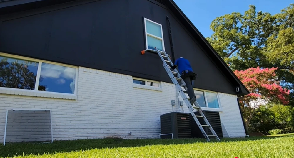 Window cleaning Santa Cruz: window cleaner climbing ladder to upper window