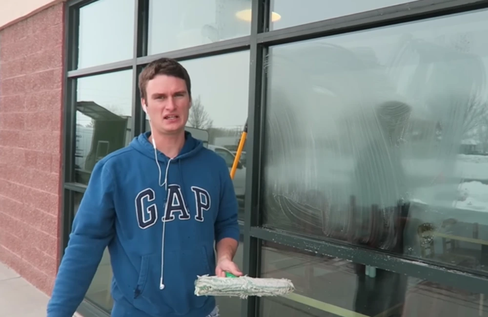 Window cleaner explaining storefront glass cleaning