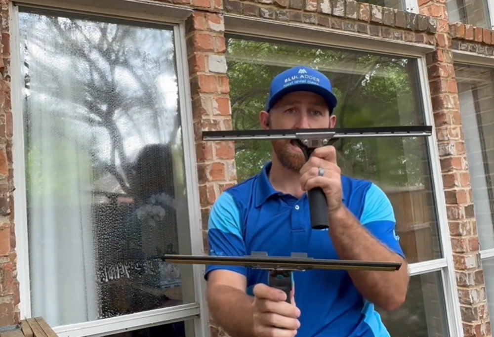 Window cleaning Santa Cruz: window cleaner holding two squeegees