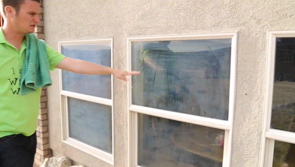 Window cleaner pointing out spotted, stained glass