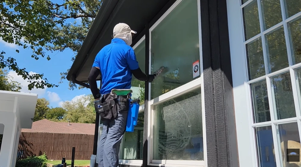 Window cleaner washing a large beach home window by our window cleaning Santa Cruz crew